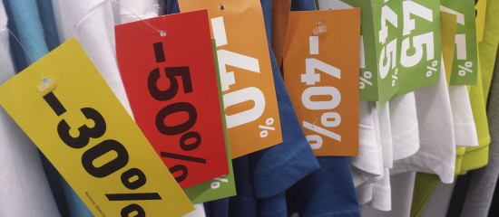 k4_24706272 Bright sale tags reading 30%, 50%, and 40% off hanging on clothing.