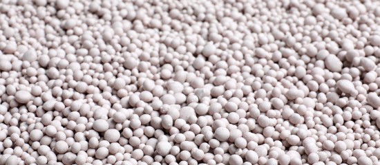k4_24774909 Close-up of numerous small white plastic resin pellets scattered across a surface.