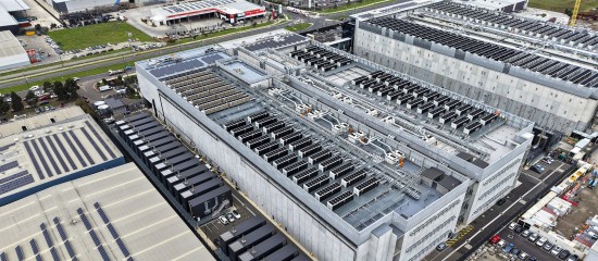 Aerial view of a large office/industrial building complex with numerous rooftop HVAC units and surrounding parking areas.